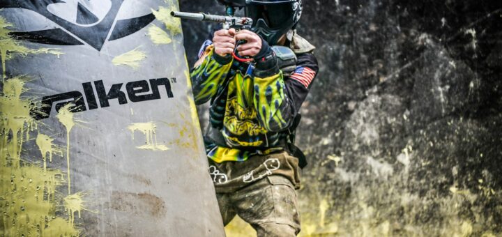 man in green and black camouflage uniform holding black and white banner